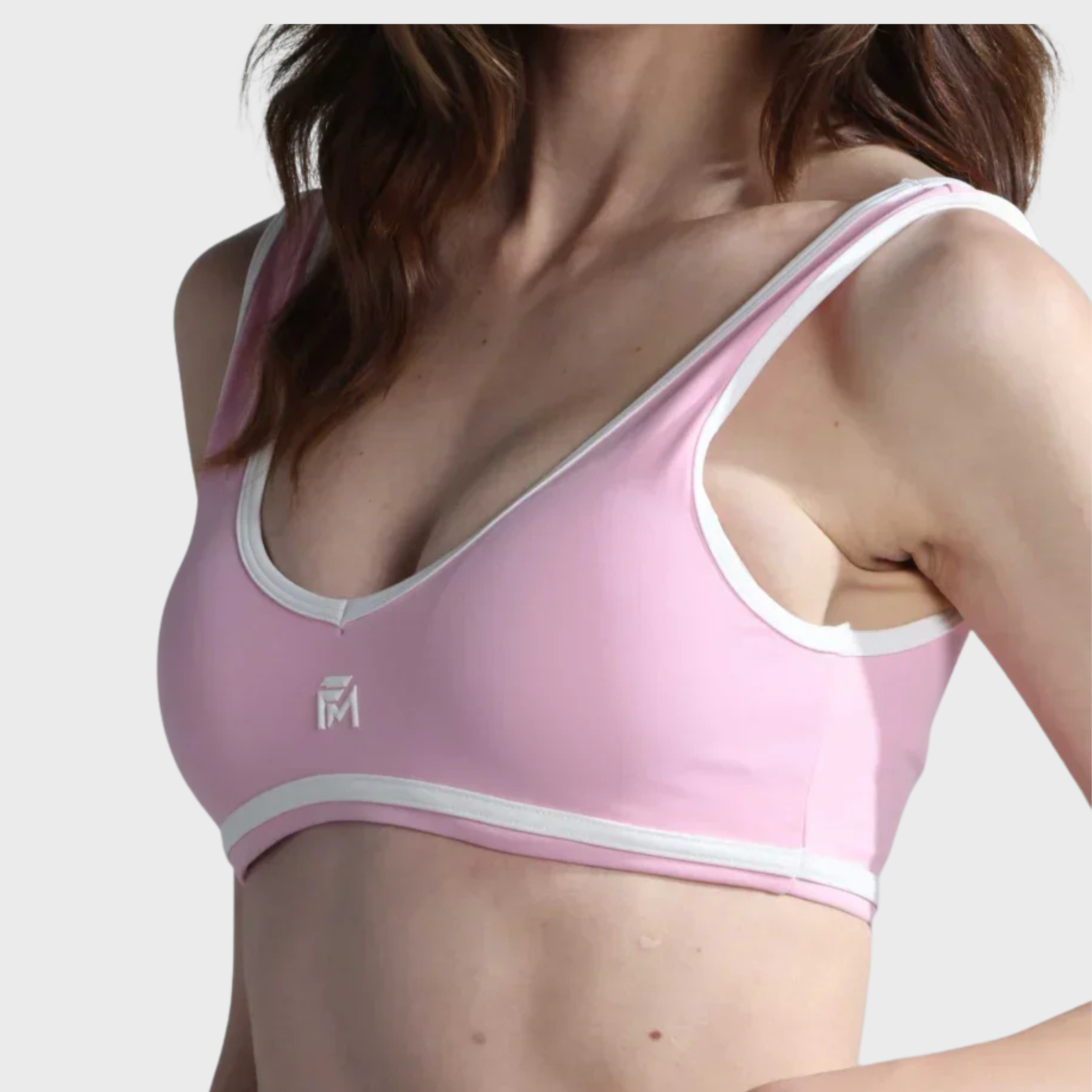 Pink sports bra with white trim on a plain background