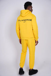 Person wearing a yellow 'FLASHMOB' tracksuit on a white background
