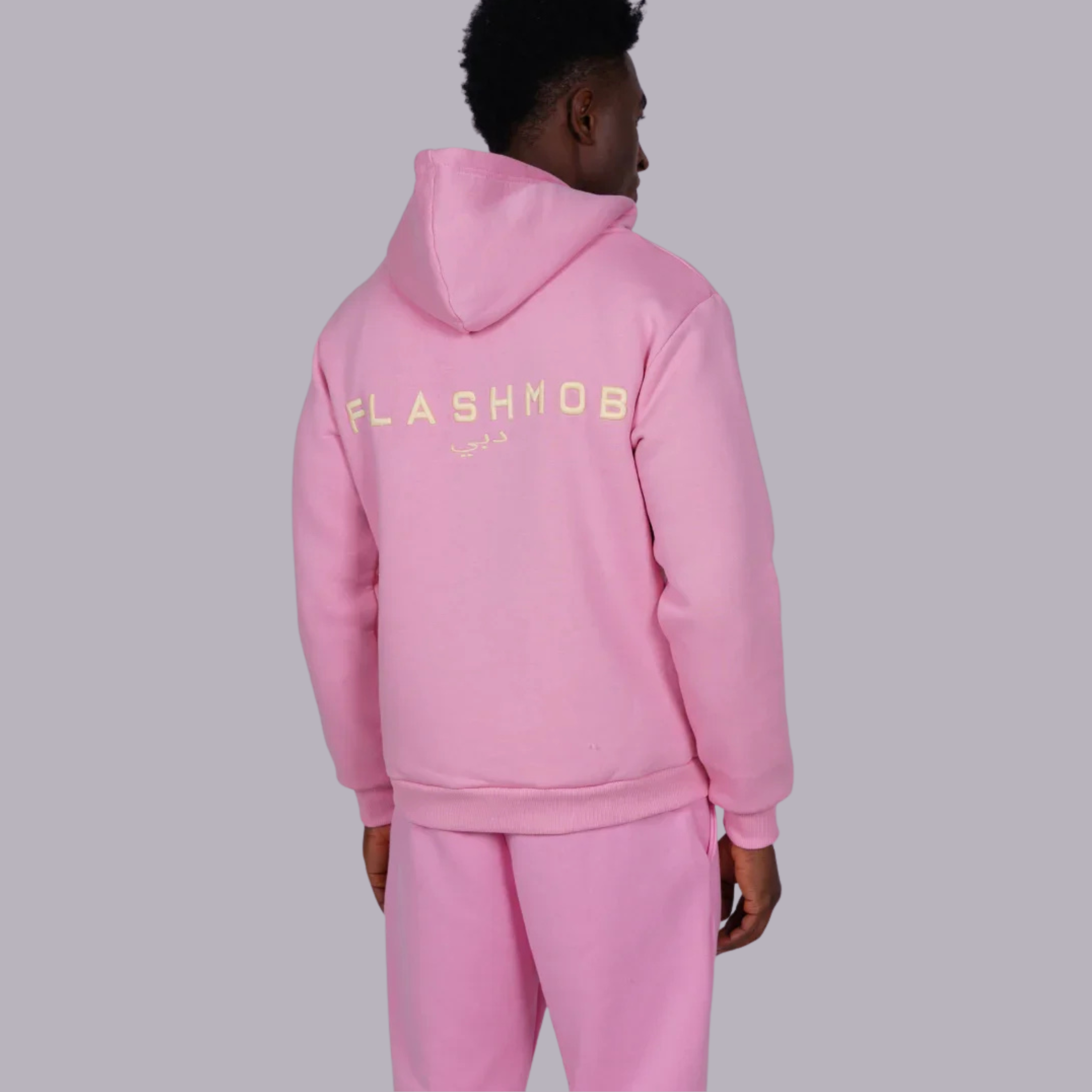 Person wearing a pink hoodie with 'FLASHMOB' text on the back against a gray background