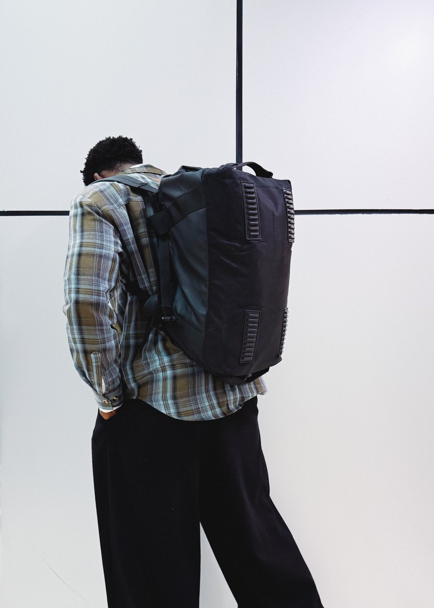 Woman wearing black convertible travel backpack in an urban setting - Flashmob Nation