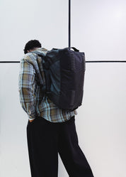 Woman wearing black convertible travel backpack in an urban setting - Flashmob Nation