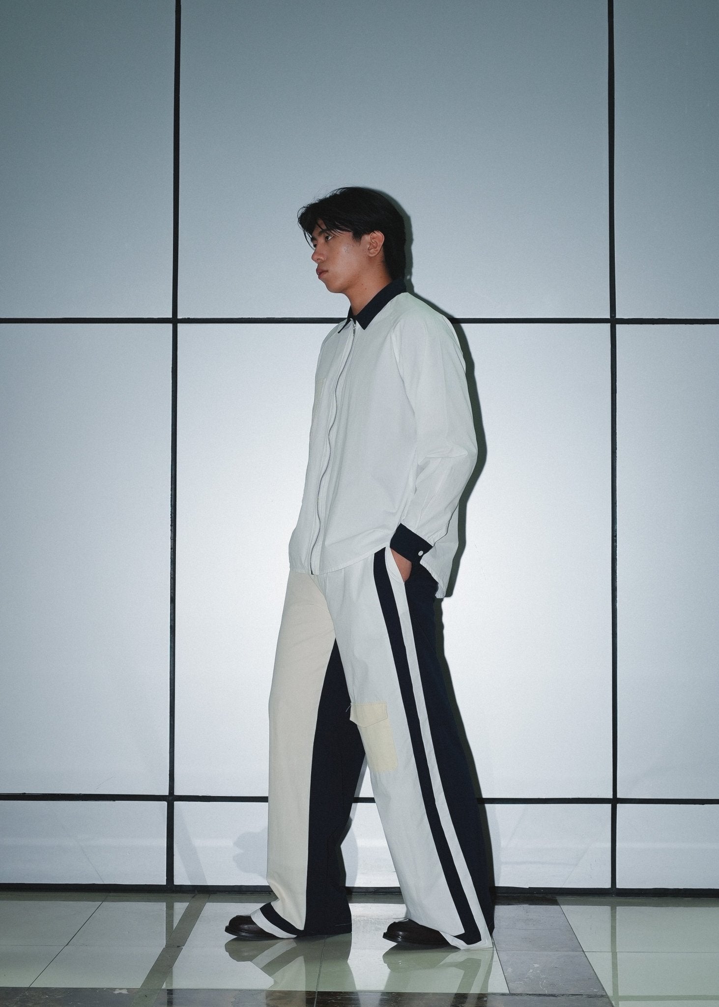 Men's urban outfit featuring structured panel poplin trousers and technical shirt.