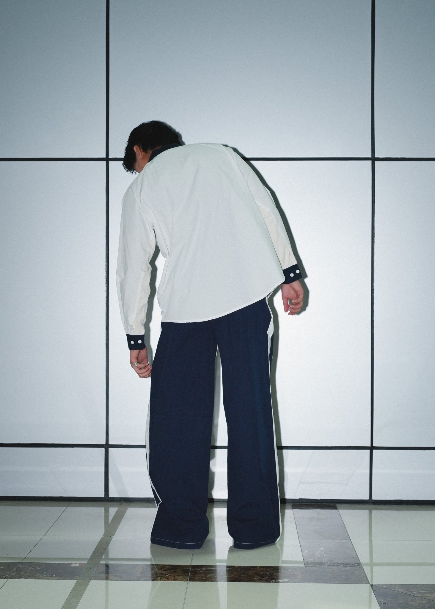 Rear profile of the poplin trousers highlighting the straight-leg fit and pocket placement.
