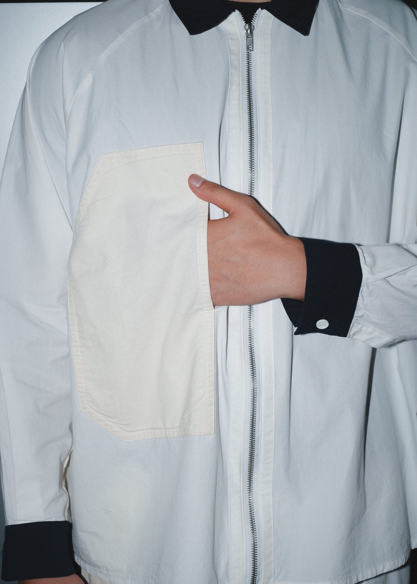 Functional side-entry pocket detail on the men's white poplin baseball shirt.