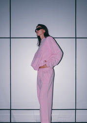 Side profile of the pink panel sweater highlighting the structured drop-shoulder fit.