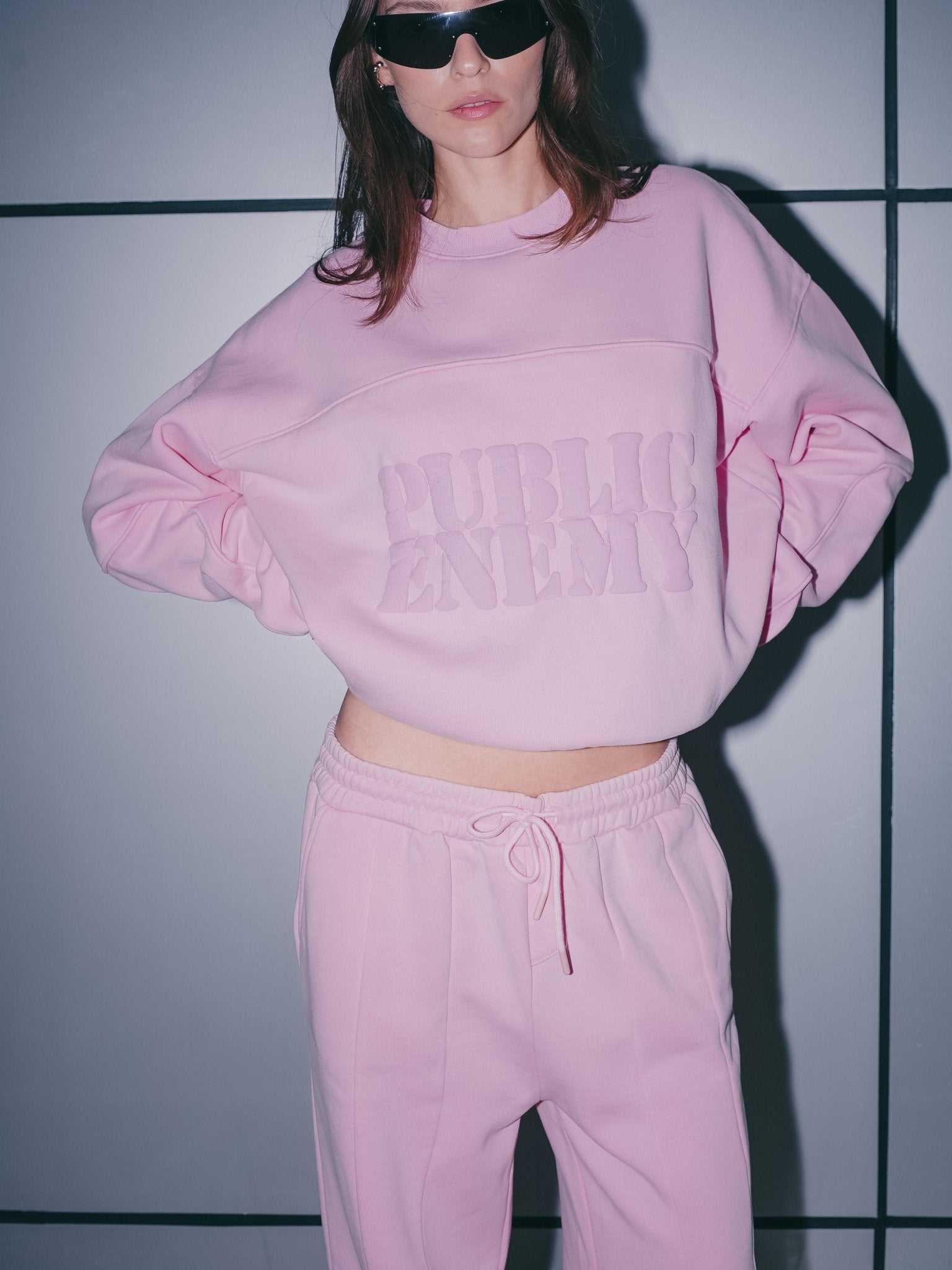 Detailed view of the architectural panelling and high-density logo on the pink sweater.