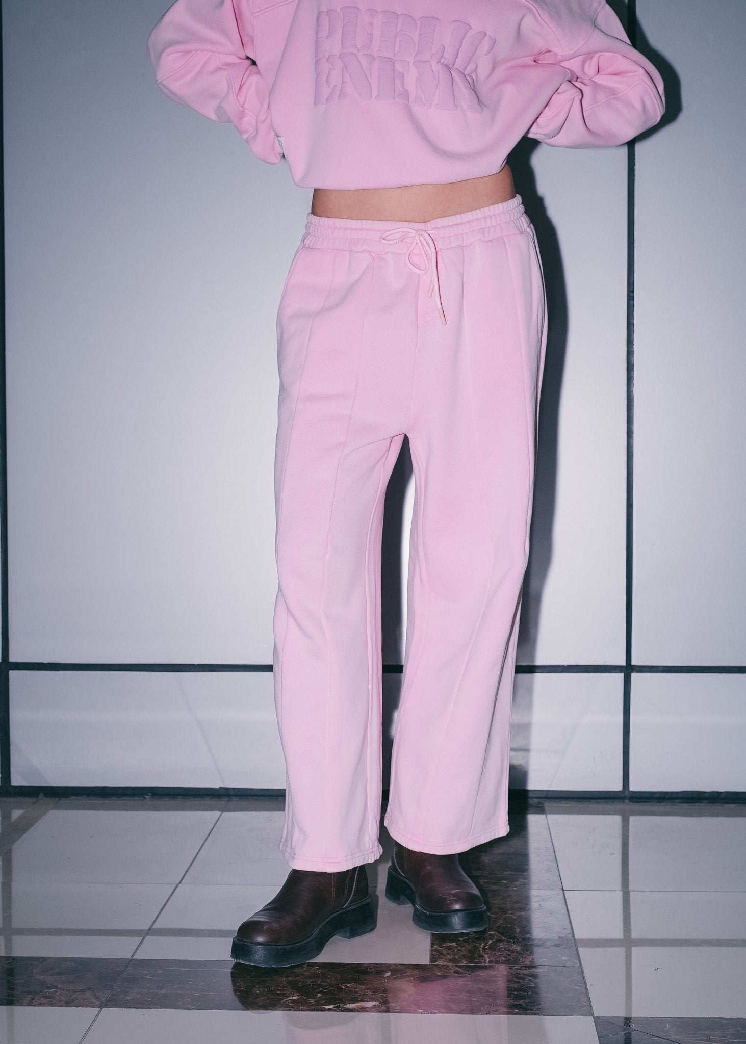 Women's streetwear outfit featuring Pink Relaxed Sweatpants and a matching signature hoodie.