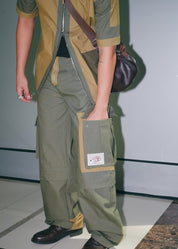Detailed view of the olive green utility cargo pants styled with streetwear overshirt.